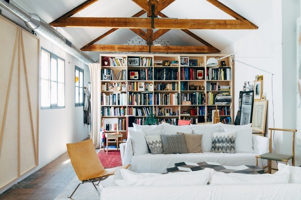 La casa del designer Alvaro Catalán de Ocón - living con divano Ghost in lino bianco, poltroncina PK22 di Poul Kjaerholm, libreria